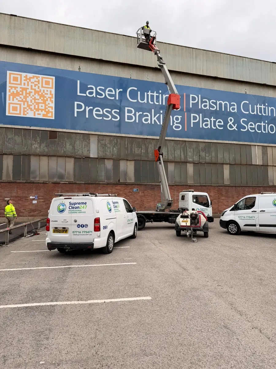 Cherry picker platform raised against a large industrial facade
