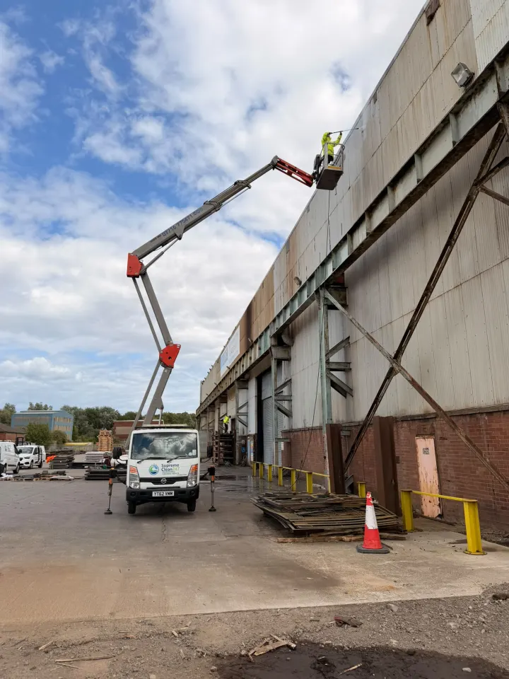 Operative cleaning commercial cladding from a cherry picker
