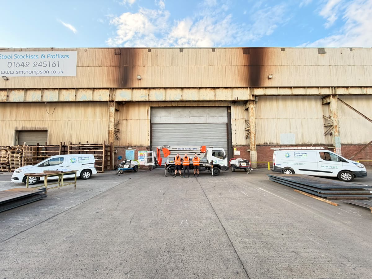 Supreme Clean 247 commercial pressure washing team and fleet outside an industrial building