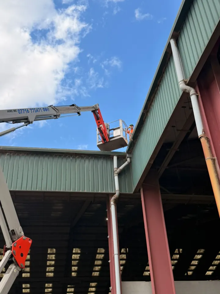Supreme Clean operative using a cherry picker for safe commercial roof access