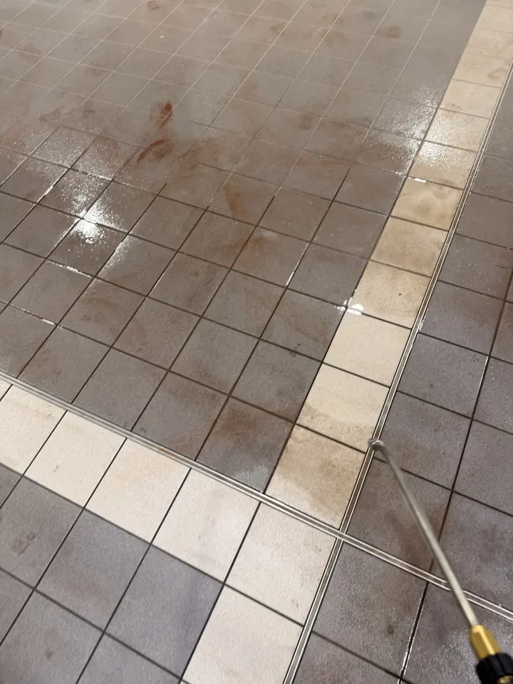 Hot-water lance lifting oil from workshop tiles