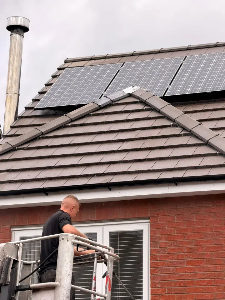 Cleaned domestic tiled roof around rooftop solar panels