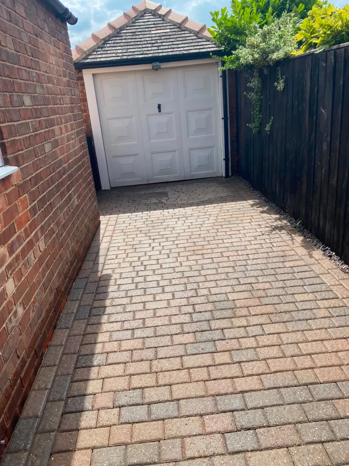 Clean block-paved driveway leading to a garage