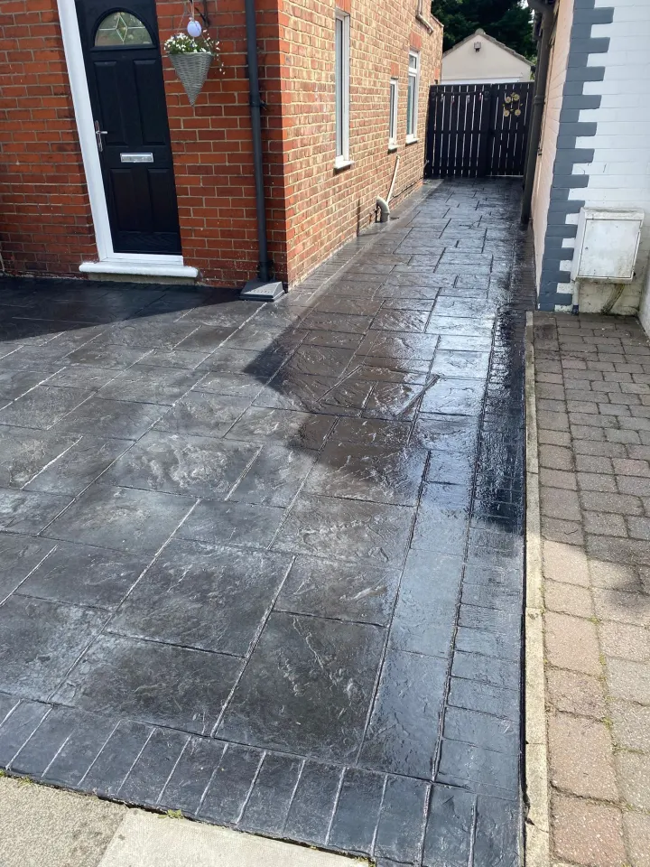 Freshly cleaned black stamped driveway and side access